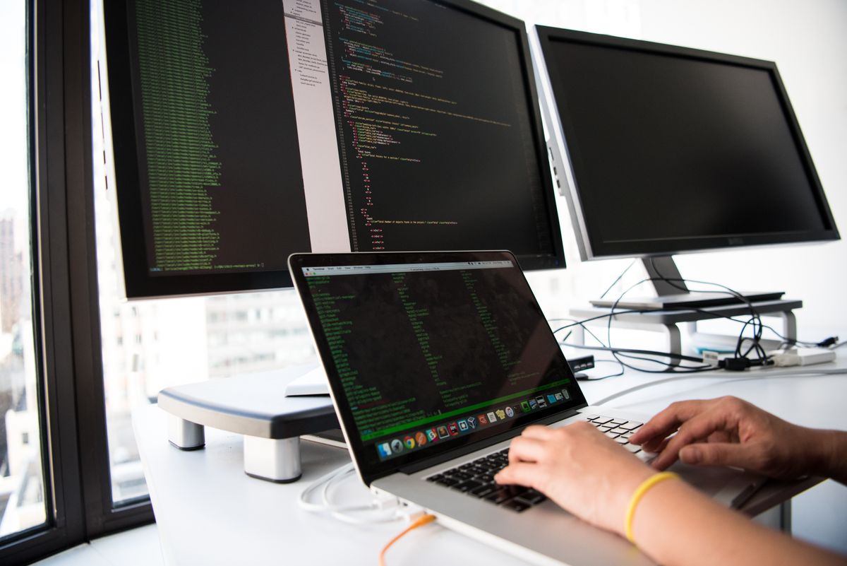 Developer at a laptop — same craft culture from Berlin stand-ups to Sarajevo PRs